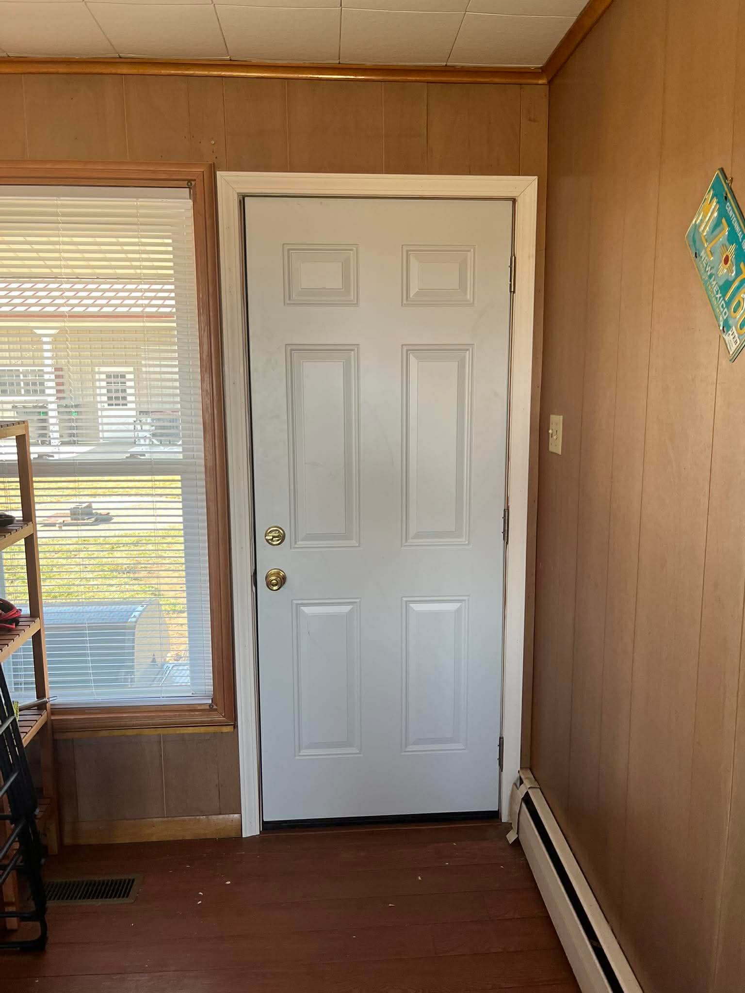 Exterior door installation with white panel door and weather stripping