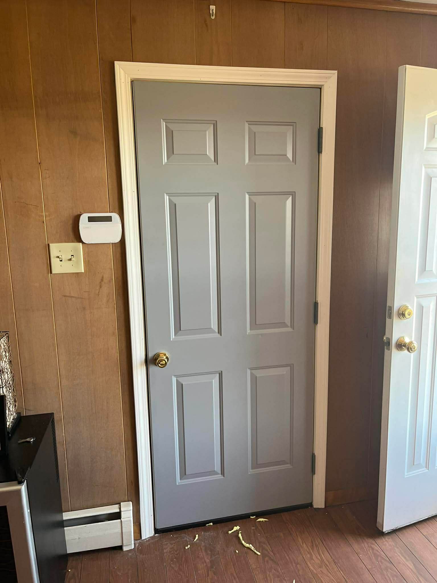 Gray six-panel interior door installation with painted trim
