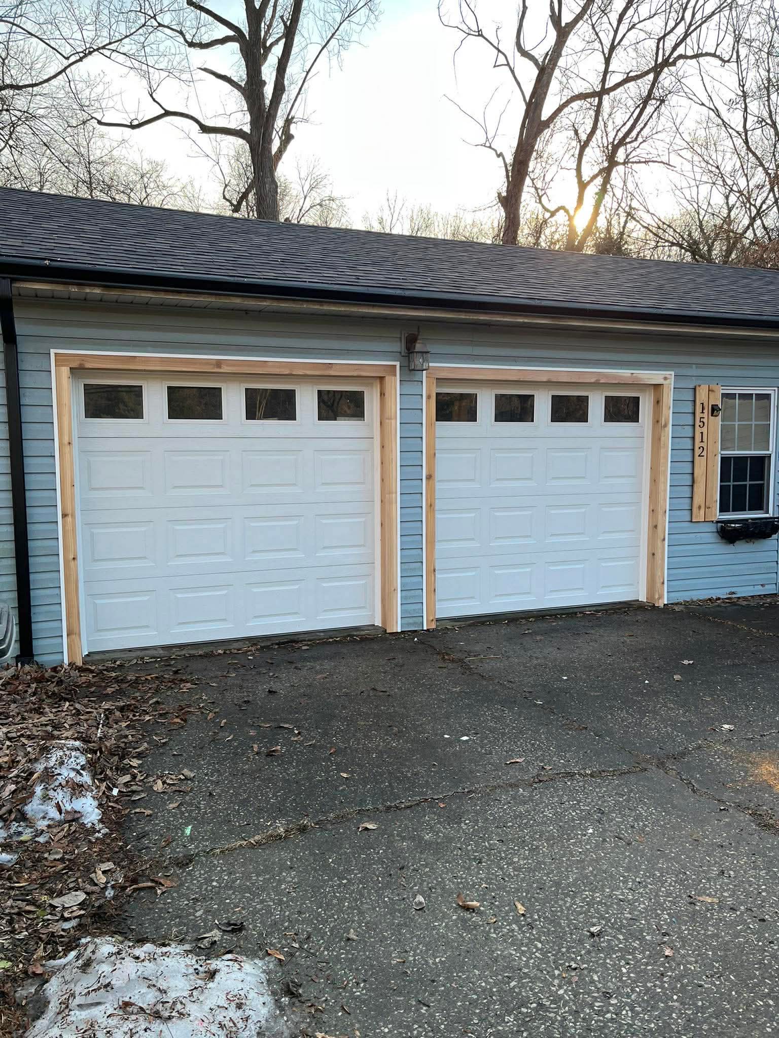 New double garage doors with window inserts and blue siding renovation