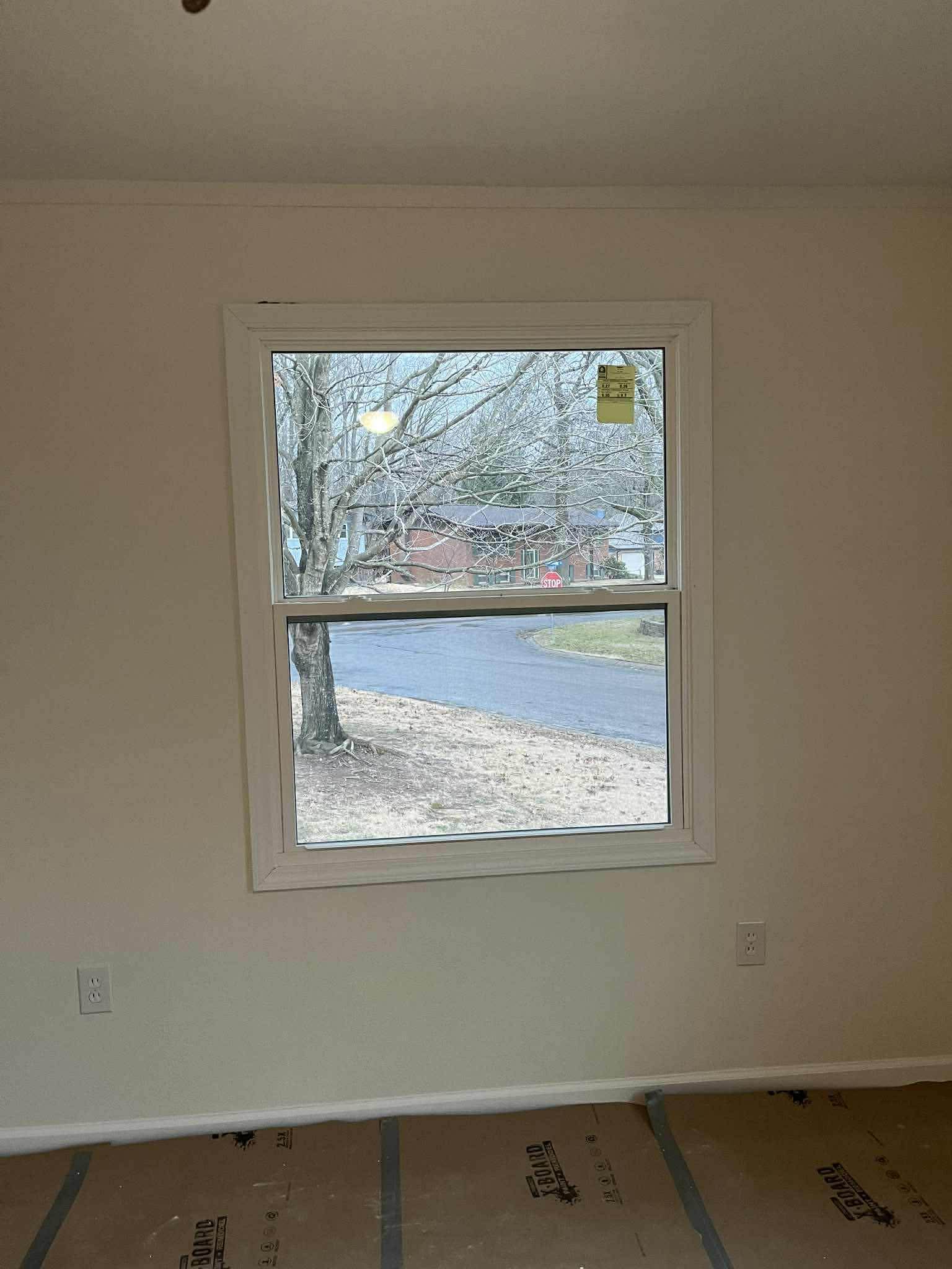 New double-hung window installation in bedroom with clean trim work